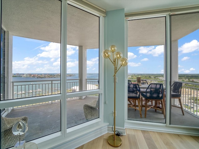 331 Cleveland St # 1806, Clearwater, FL 33755 - doorway to outside featuring a water view, a wall of windows, plenty of natural light, and wood finished floors