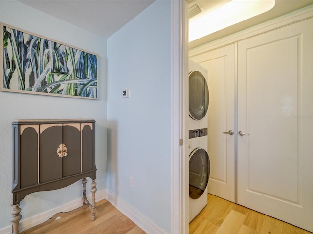 331 Cleveland St # 1806, Clearwater, FL 33755 - laundry area featuring stacked washing maching and dryer, baseboards, and light wood-style flooring