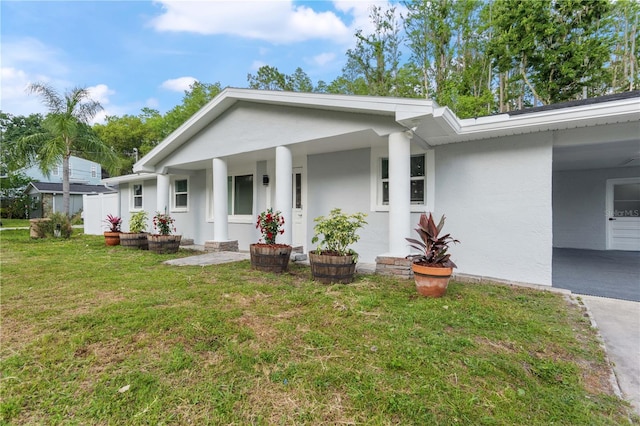 view of front of property featuring a porch, stucco siding, and a front yard