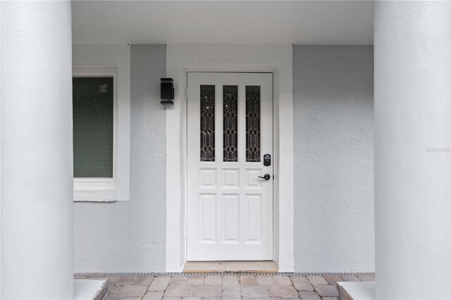 doorway to property featuring stucco siding