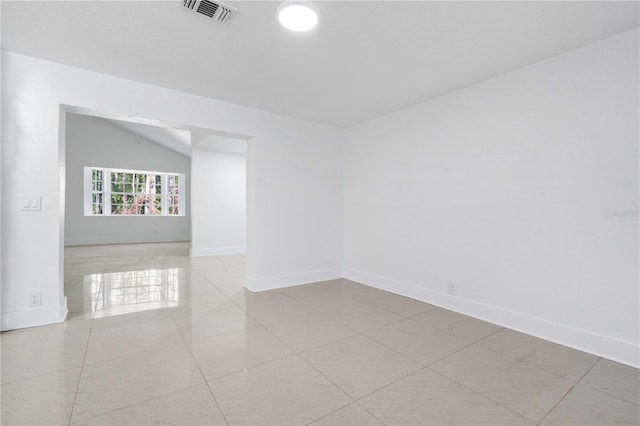 spare room featuring baseboards, visible vents, lofted ceiling, and tile patterned flooring