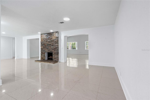 unfurnished living room featuring baseboards, recessed lighting, a stone fireplace, and visible vents