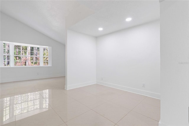 tiled empty room with baseboards, recessed lighting, and lofted ceiling