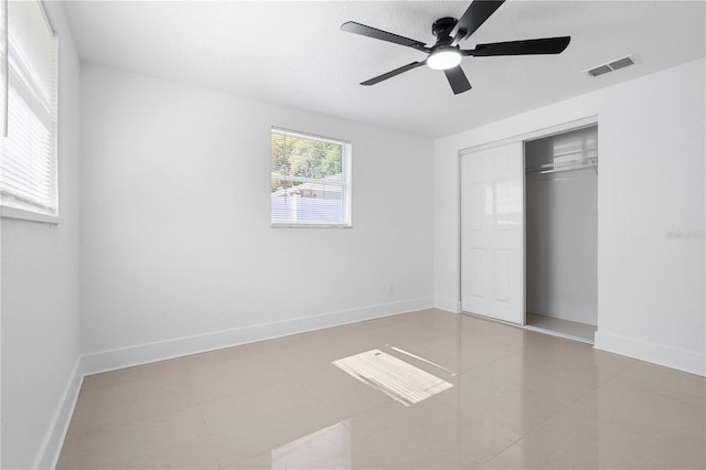 unfurnished bedroom with tile patterned floors, visible vents, baseboards, and a closet