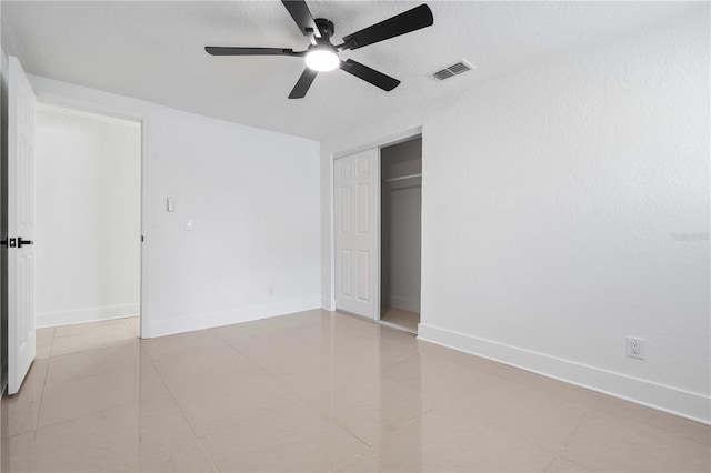 unfurnished bedroom with baseboards, visible vents, tile patterned flooring, and a closet