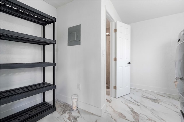 bathroom featuring baseboards, marble finish floor, and electric panel