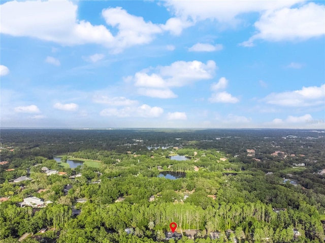 drone / aerial view featuring a water view and a forest view