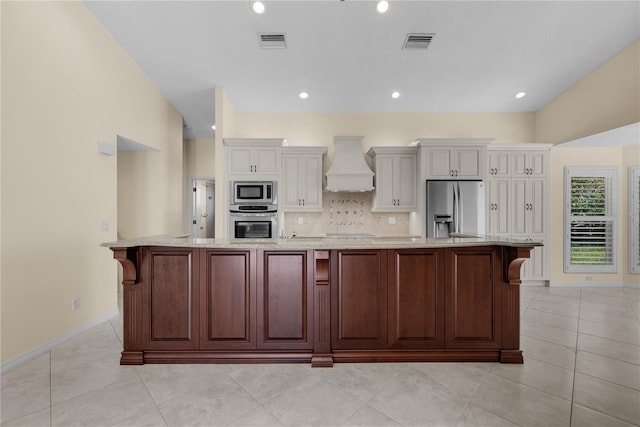 5290 White Sand Cir NE, Saint Petersburg, FL 33703 - kitchen with stainless steel appliances, custom exhaust hood, a large island, light stone countertops, and baseboards