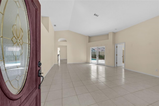 5290 White Sand Cir NE, Saint Petersburg, FL 33703 - foyer entrance featuring light tile patterned floors, french doors, high vaulted ceiling, arched walkways, and baseboards