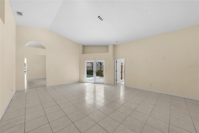 5290 White Sand Cir NE, Saint Petersburg, FL 33703 - spare room with french doors, light tile patterned floors, high vaulted ceiling, and baseboards