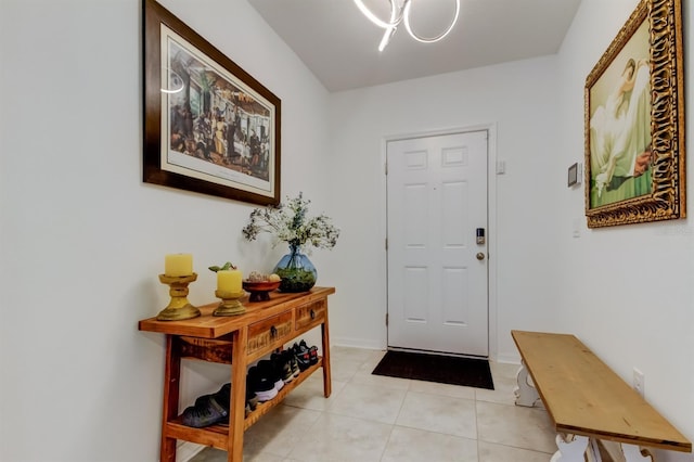 doorway with light tile patterned floors, baseboards, and a notable chandelier