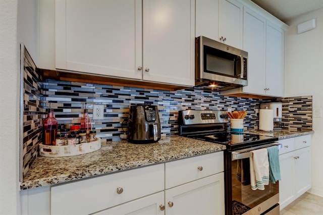 kitchen with stainless steel appliances, light stone counters, and tasteful backsplash