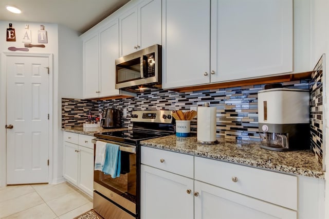 kitchen featuring appliances with stainless steel finishes, backsplash, white cabinets, and light stone countertops