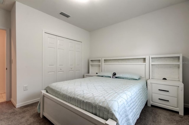 bedroom featuring baseboards, a closet, dark carpet, and visible vents