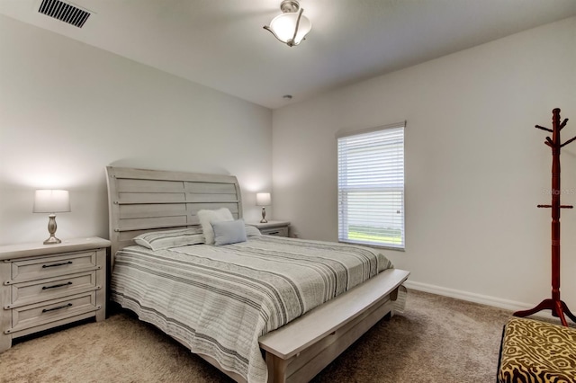 bedroom featuring visible vents, baseboards, and light carpet