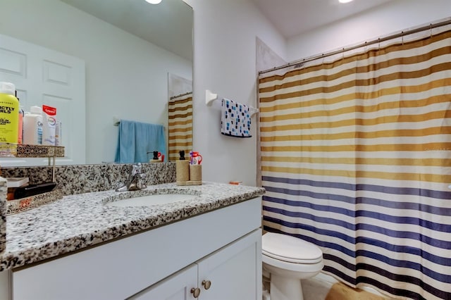 bathroom with toilet, a shower with shower curtain, and vanity