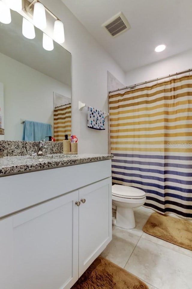 bathroom featuring vanity, tile patterned flooring, toilet, and visible vents