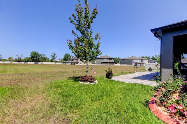 view of yard featuring a patio and a residential view