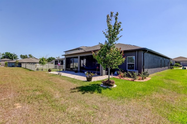 back of property with a lawn, a patio, and fence