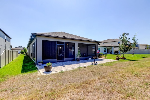 rear view of house featuring a sunroom, a lawn, fence, and a patio area