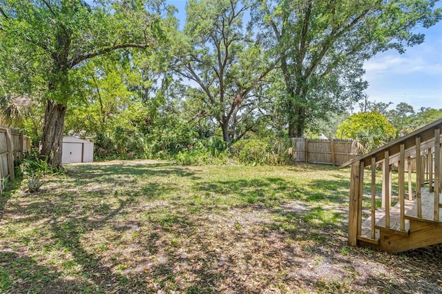 view of yard with a storage shed, an outdoor structure, and a fenced backyard