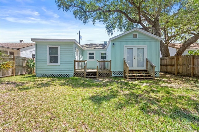 back of house featuring a fenced backyard, a lawn, and a deck