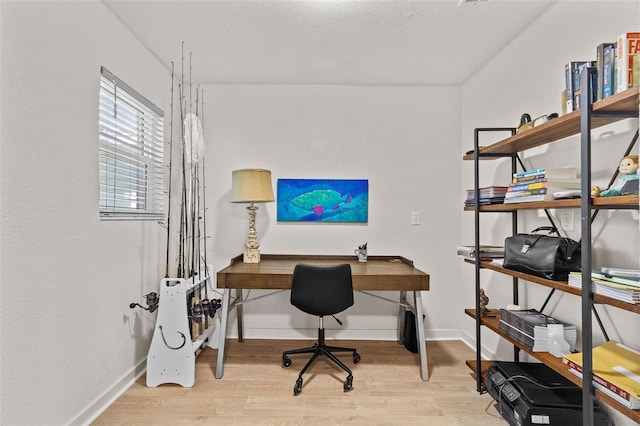 office space with baseboards and light wood-type flooring