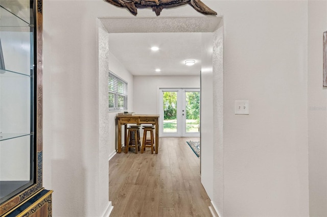 corridor featuring baseboards and light wood-style flooring