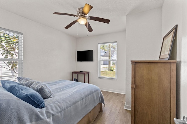 bedroom with baseboards, ceiling fan, and wood finished floors