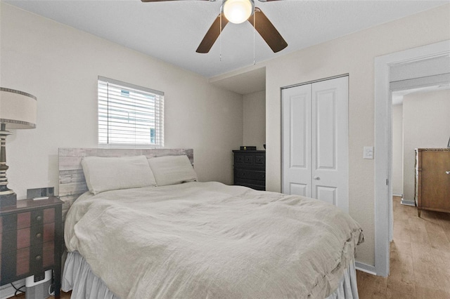 bedroom with a ceiling fan, a closet, and light wood-type flooring