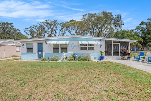 view of front of house with a front yard, a sunroom, fence, concrete driveway, and an attached carport