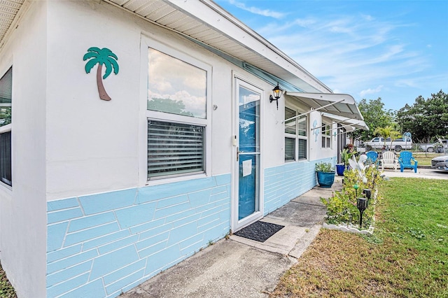 doorway to property featuring a lawn