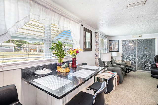 dining space with a textured ceiling, speckled floor, and visible vents