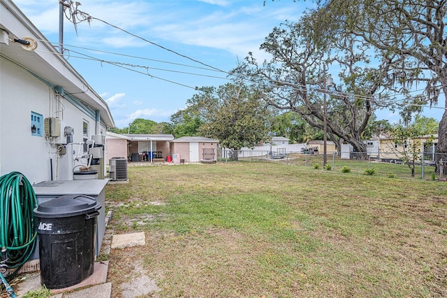 view of yard featuring central AC unit and fence