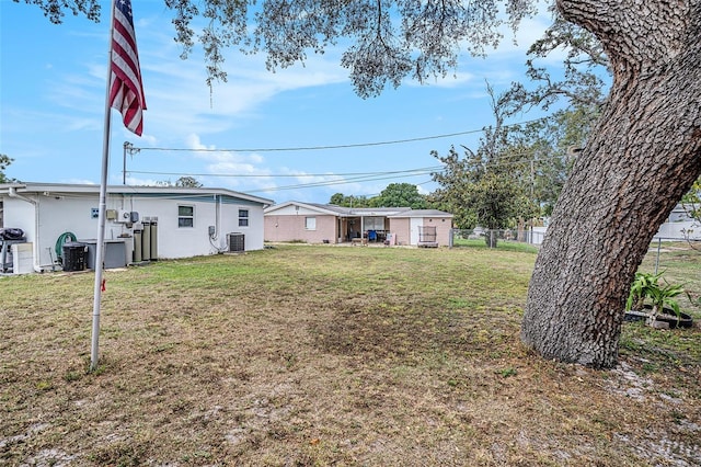 view of yard with central air condition unit and fence