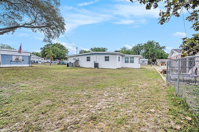 view of yard with central AC and fence