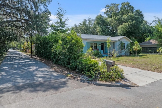 view of front of home featuring a porch, a front lawn, and driveway