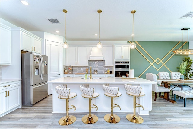 kitchen with white cabinets, appliances with stainless steel finishes, and visible vents