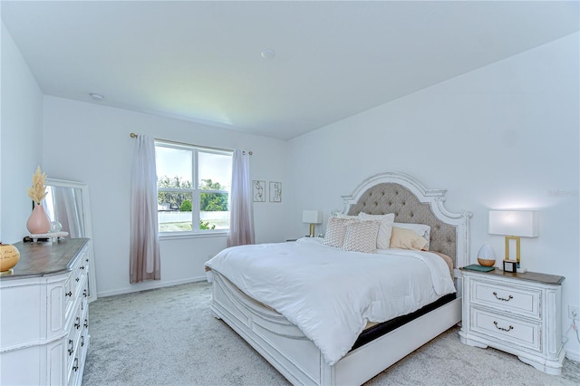 bedroom featuring baseboards and light colored carpet