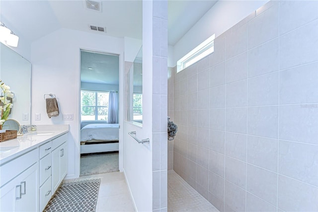 ensuite bathroom with connected bathroom, double vanity, visible vents, and a sink