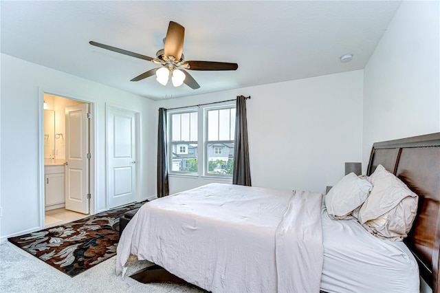 bedroom featuring baseboards, ceiling fan, and ensuite bath
