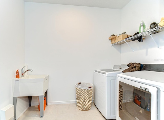 washroom with separate washer and dryer, baseboards, and laundry area