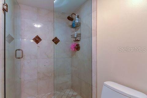 bathroom with toilet and a stall shower