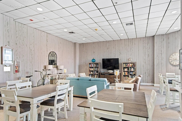 dining room with wooden walls, recessed lighting, and visible vents