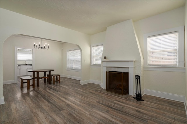 1606 S Arrawana Ave, Tampa, FL 33629 - living area featuring arched walkways, a chandelier, dark wood finished floors, baseboards, and a fireplace with flush hearth