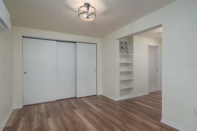 1606 S Arrawana Ave, Tampa, FL 33629 - unfurnished bedroom with a closet, baseboards, wood finished floors, and a wall mounted air conditioner