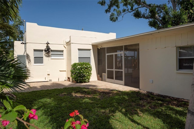 1606 S Arrawana Ave, Tampa, FL 33629 - back of property with a sunroom, a lawn, and stucco siding