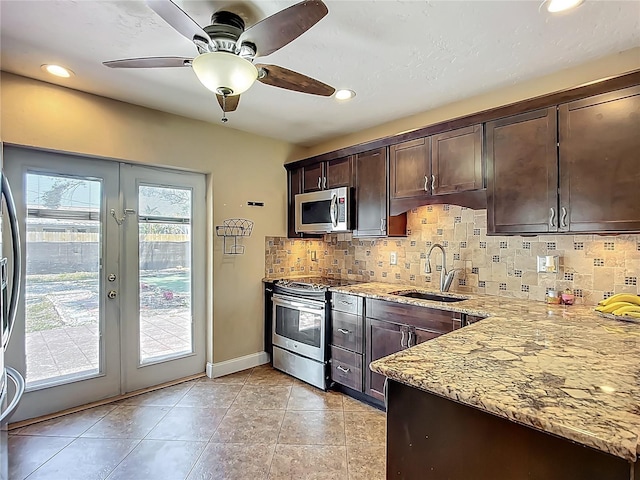 10931 110th Ave, Seminole, FL 33778 - kitchen featuring stainless steel appliances, a sink, light stone countertops, dark brown cabinetry, and recessed lighting