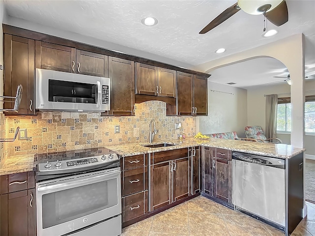 10931 110th Ave, Seminole, FL 33778 - kitchen with appliances with stainless steel finishes, ceiling fan, a sink, light stone counters, and recessed lighting