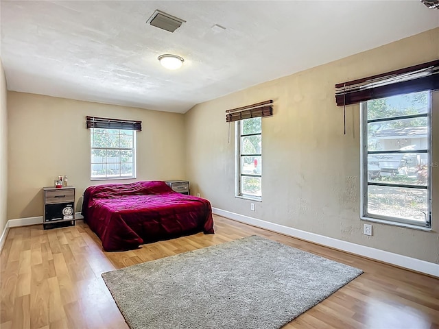 10931 110th Ave, Seminole, FL 33778 - bedroom featuring multiple windows, wood finished floors, and baseboards